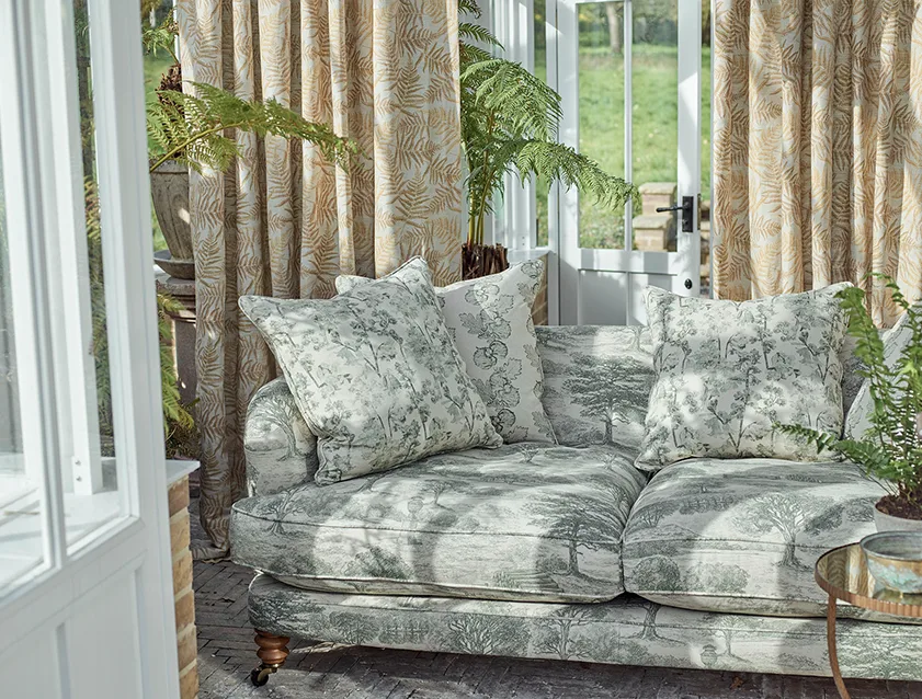Helmsley 3 seater sofa in Woodland Toile Forest Green, scatters in Coppice Stripe Forest Green, Woodland Flora Forest Green and curtains in Frond All Over Sandstone
